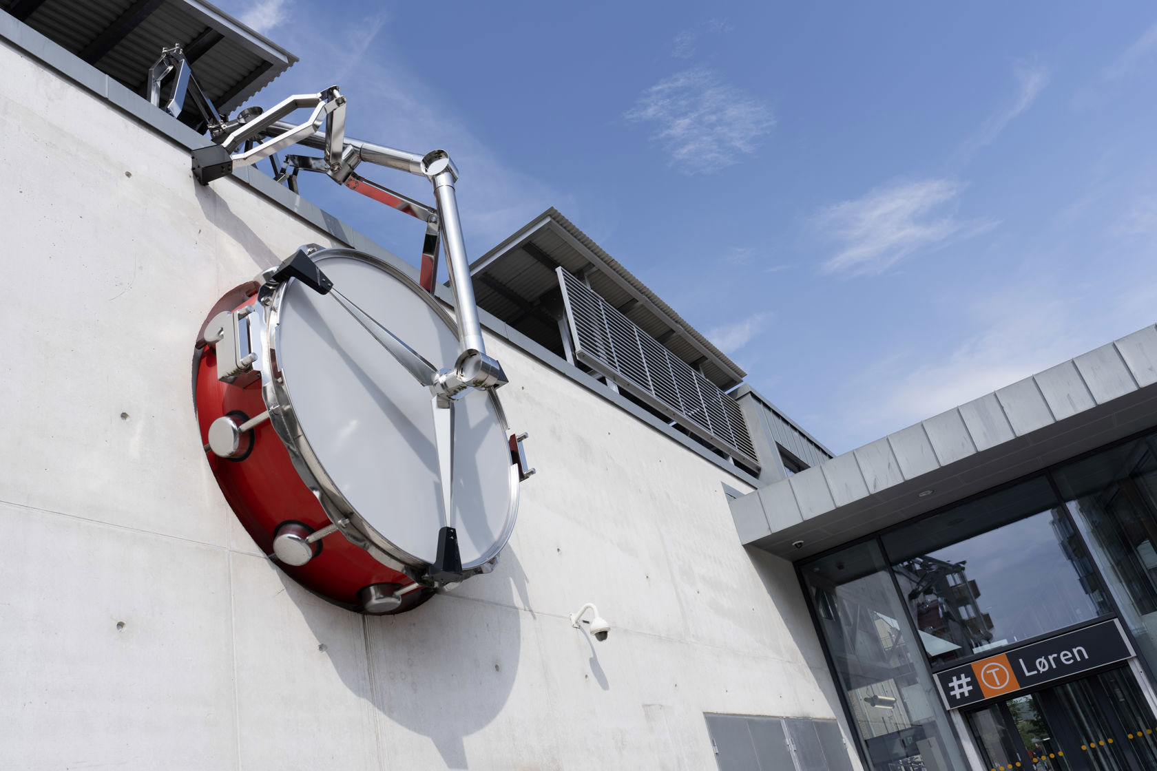 Stor trommeskulptur ved inngangen til Løren T-banestasjon.