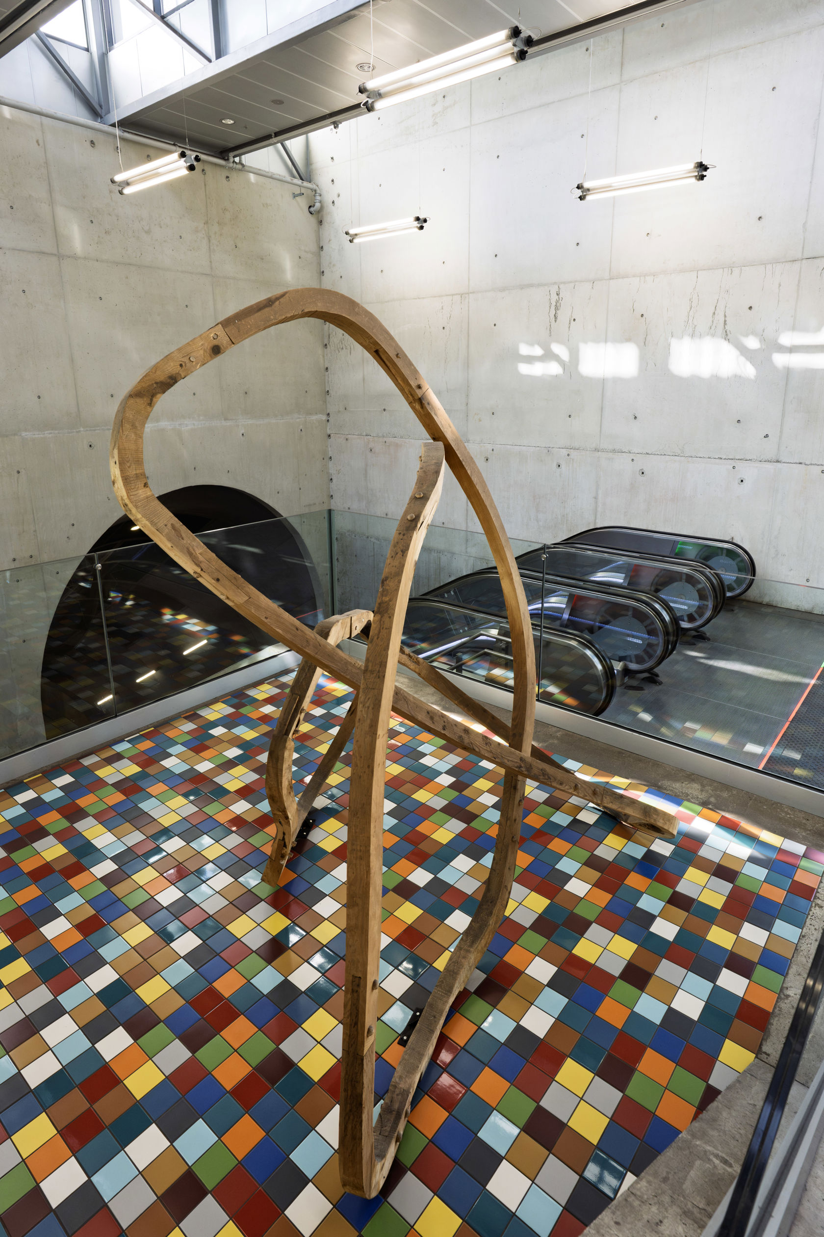 Kunstinstallasjon av en treskulptur ved rulletrappene på Løren T-banestasjon.