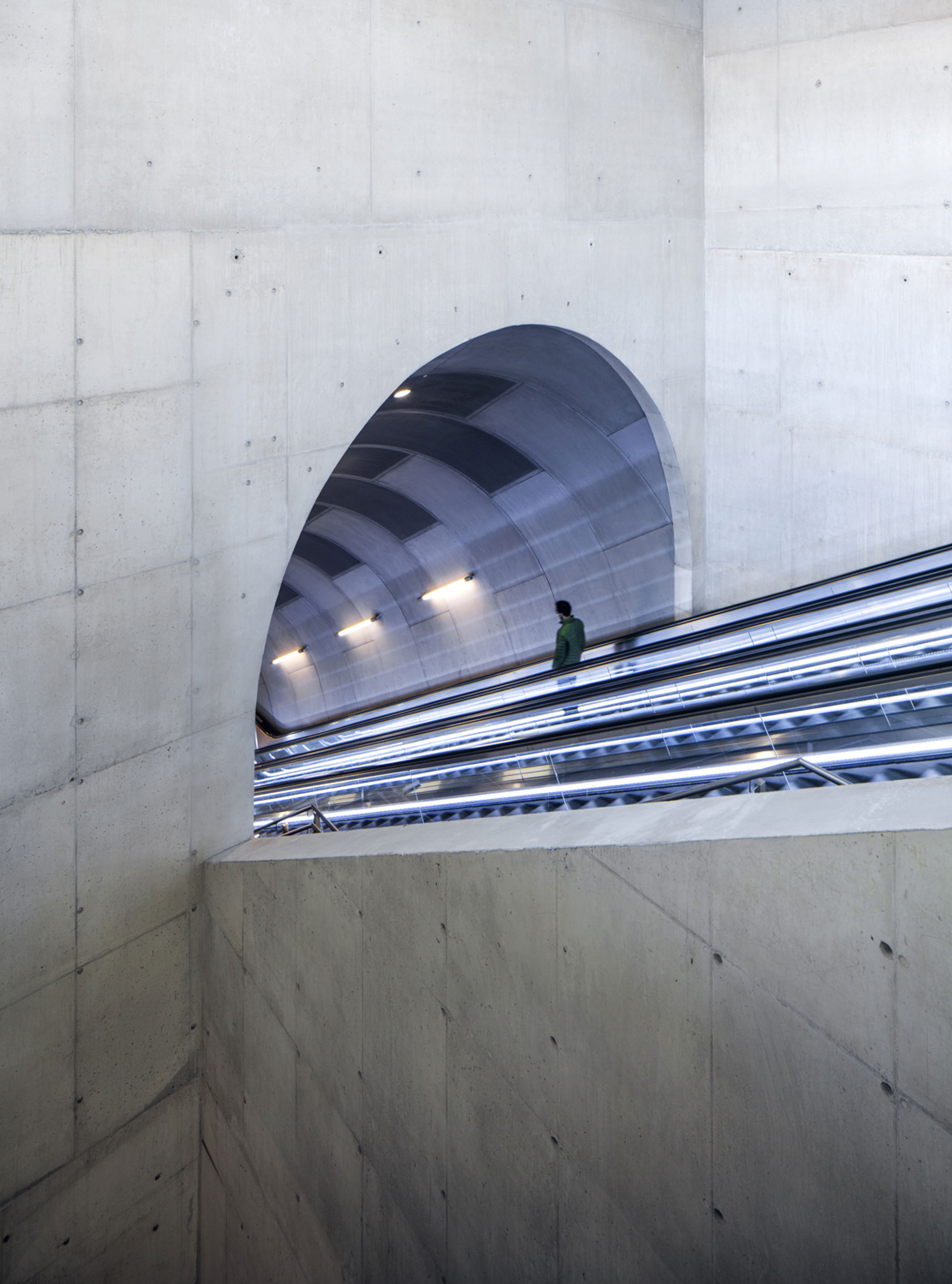 Tunnelformede rulletrapper som leder ned til plattformnivå på Løren T-banestasjon.