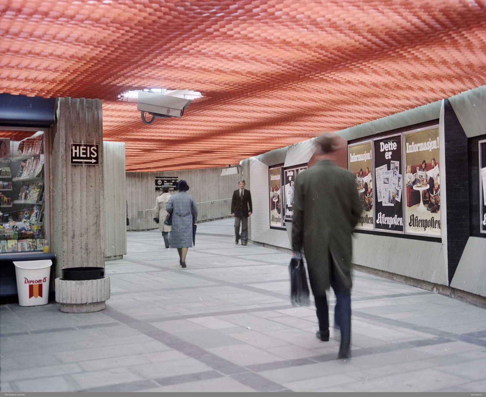 Vestibyle på Sentrum stasjon med rødoransje kassett-himling og betongvegger.