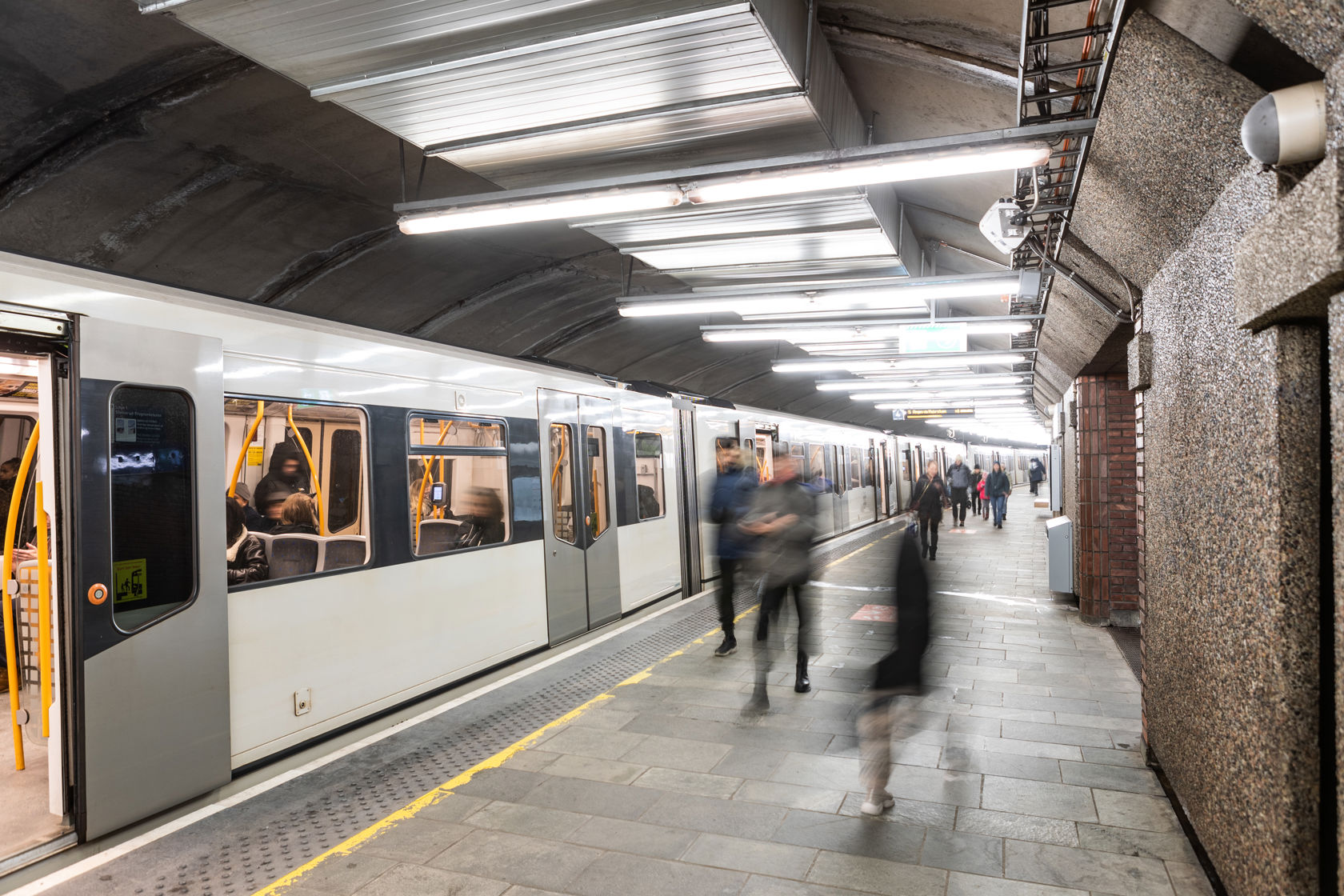 T-banetog ved plattformen på Tøyen T-banestasjon med reisende.